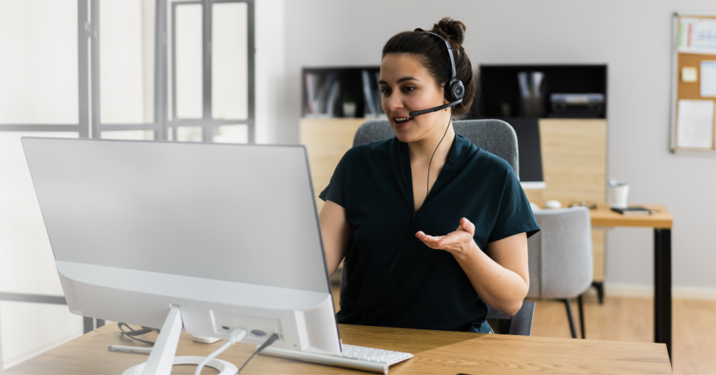 person working on laptop and talking with headset