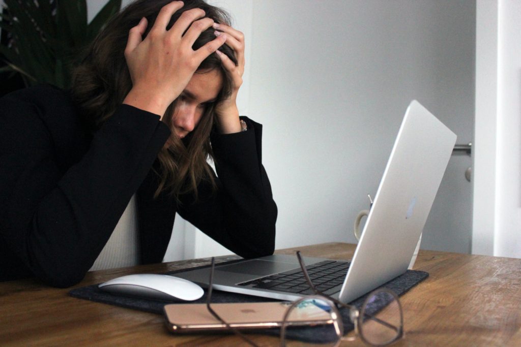 Stressed person looking at laptop