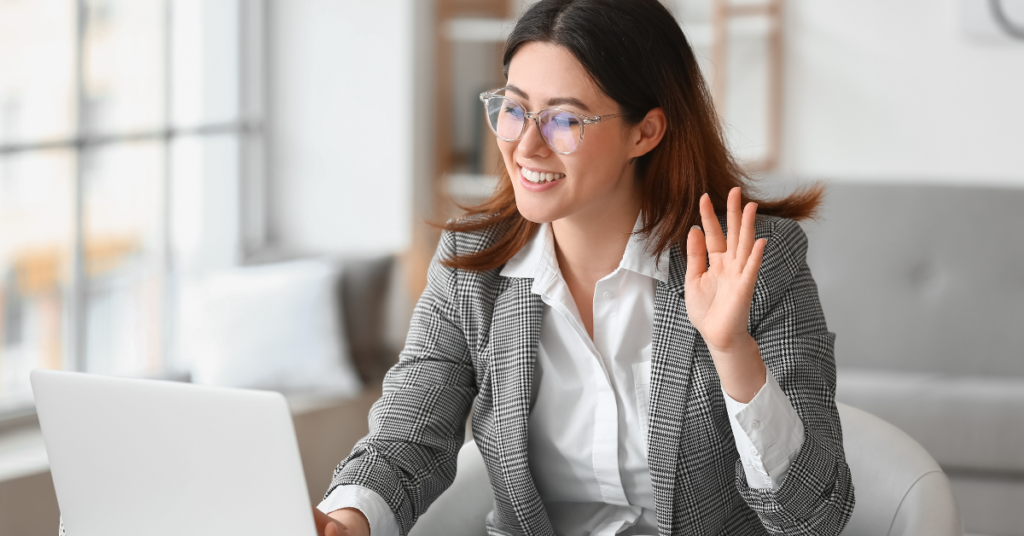 Person using laptop and waving