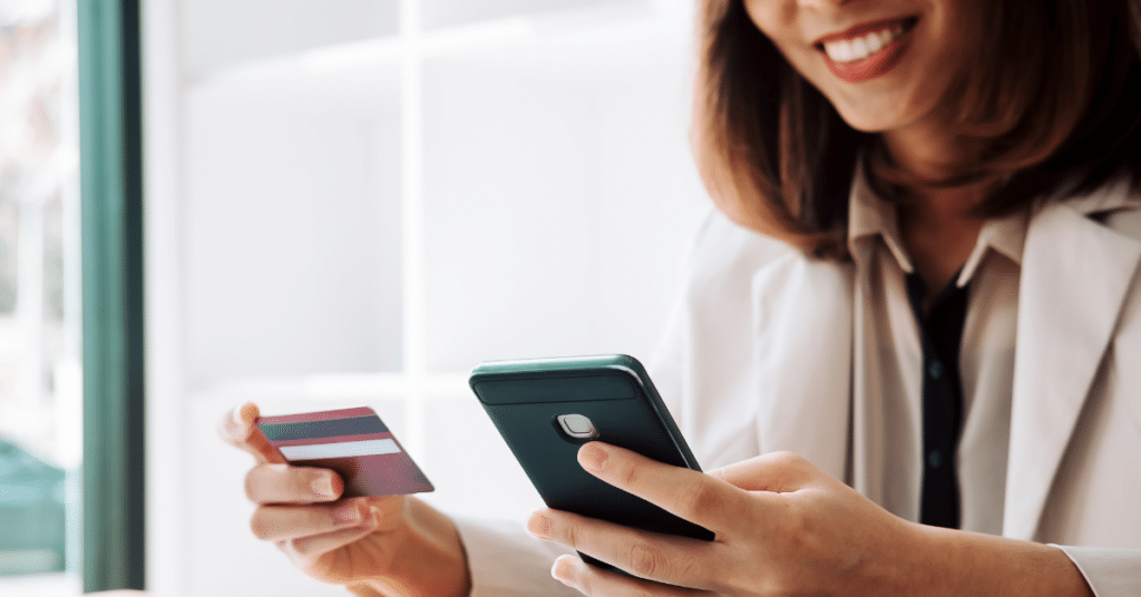Person using mobile device and credit card