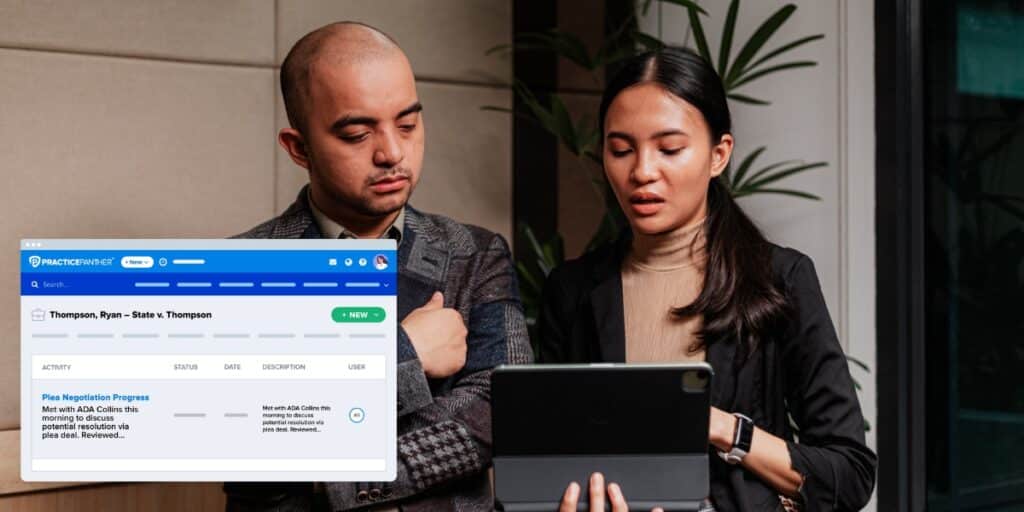 A woman lawyer showing her male coworker the PracticePanther software documents dashboard on a tablet in her left hand