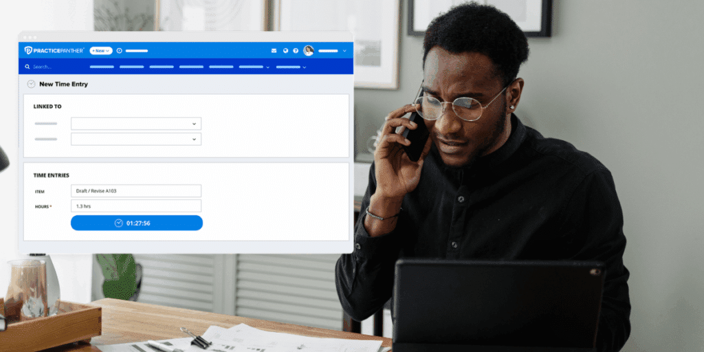 Male lawyer at his desk and on the phone with a client looking at a case using PracticePanther on his computer.